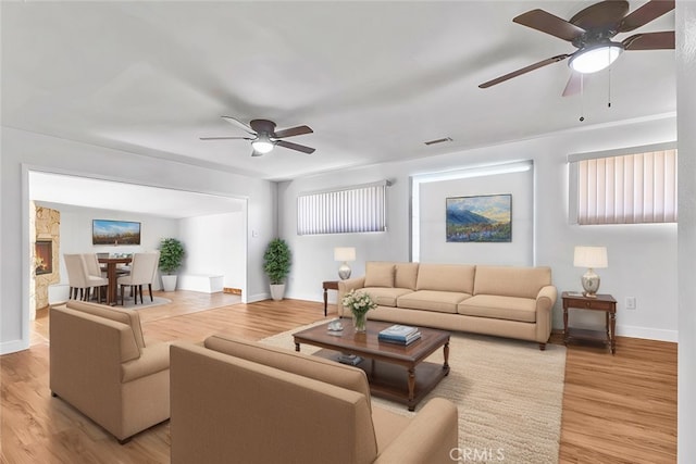 living room with ceiling fan and light wood-type flooring