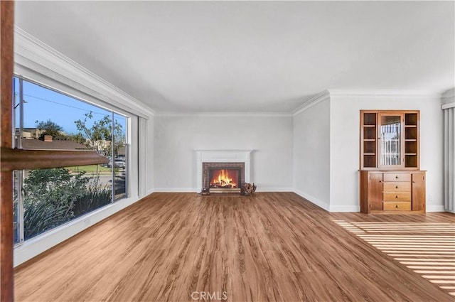 unfurnished living room with a fireplace, ornamental molding, and hardwood / wood-style flooring