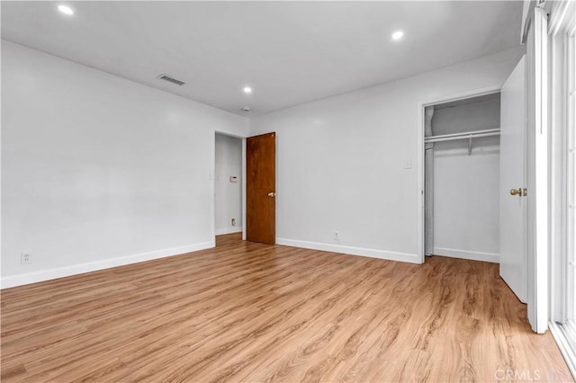 unfurnished bedroom with a closet and light hardwood / wood-style flooring