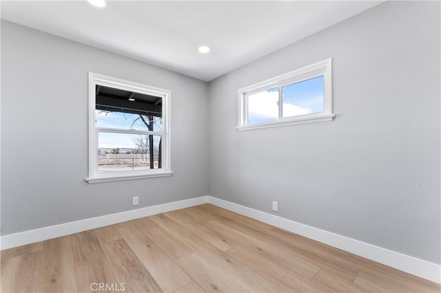 spare room featuring light wood-type flooring and a wealth of natural light