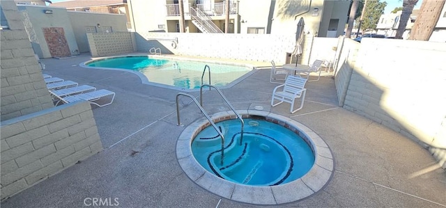 view of pool featuring a patio area and a hot tub