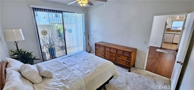 bedroom with ceiling fan, light colored carpet, and ensuite bathroom