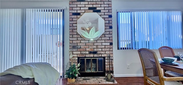 living room featuring a brick fireplace and hardwood / wood-style flooring