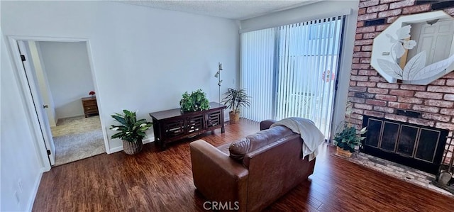 living room with plenty of natural light, a fireplace, a textured ceiling, and dark hardwood / wood-style floors