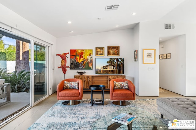 living area featuring vaulted ceiling and light tile patterned floors