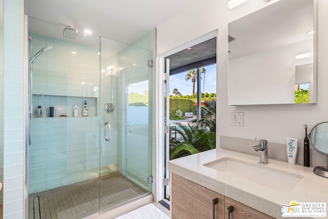 bathroom featuring walk in shower and vanity