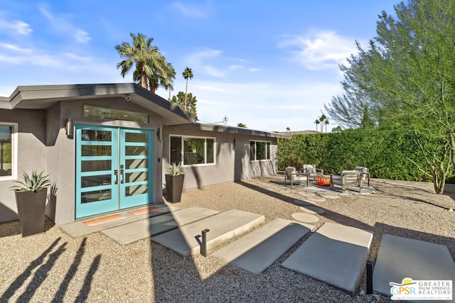 back of property featuring an outdoor fire pit, french doors, and a patio