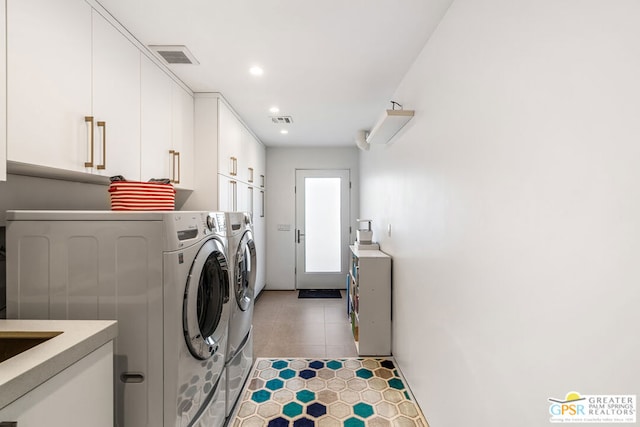 clothes washing area featuring washer and clothes dryer and cabinets