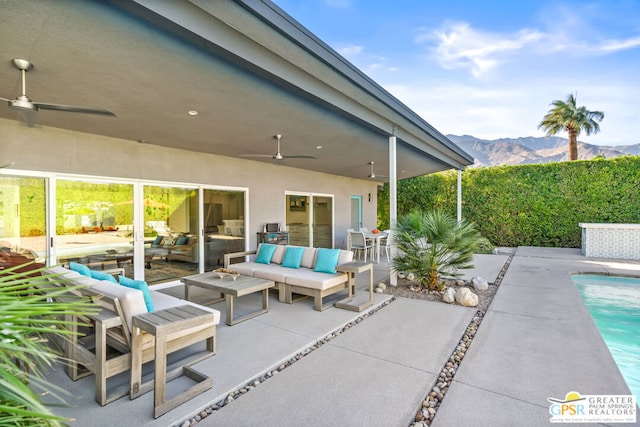 view of patio featuring ceiling fan, an outdoor hangout area, and a mountain view