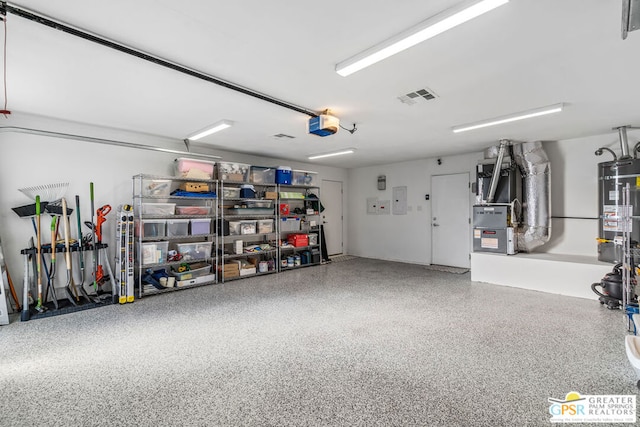 garage with gas water heater and a garage door opener