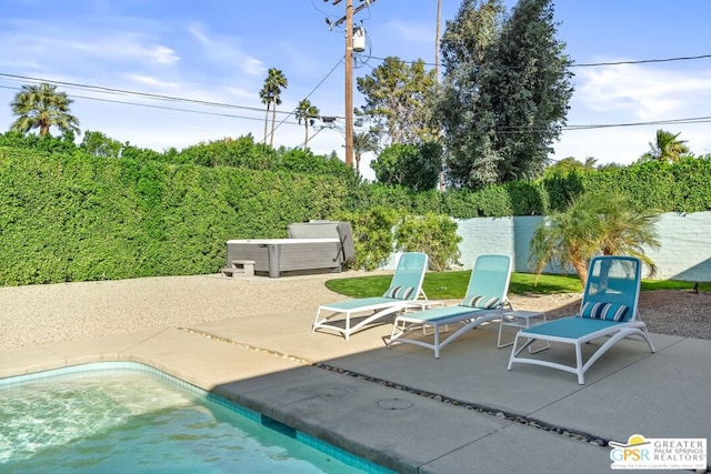 view of pool with a hot tub and a patio