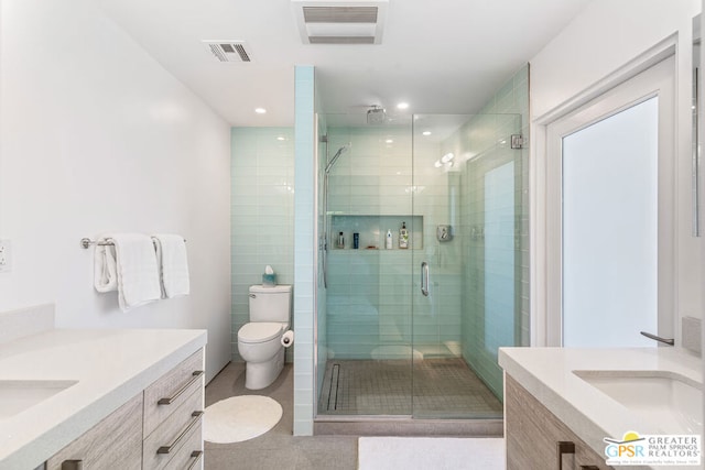 bathroom with a shower with door, vanity, and toilet