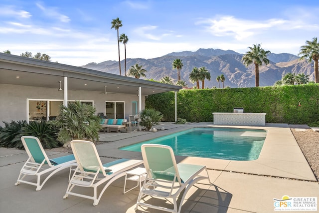 view of swimming pool featuring a patio area, ceiling fan, a mountain view, and outdoor lounge area