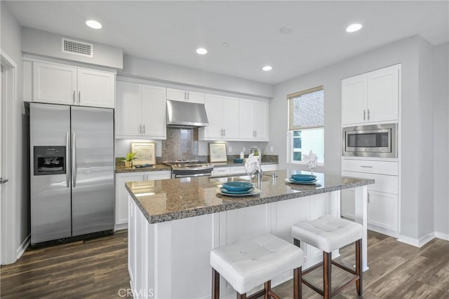 kitchen featuring appliances with stainless steel finishes, sink, white cabinetry, and a center island with sink