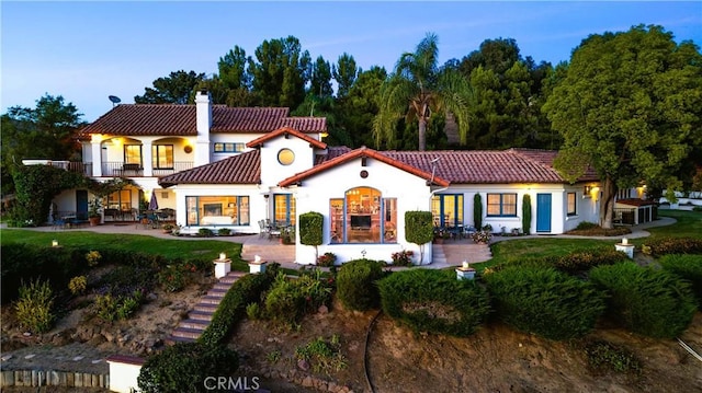 rear view of property featuring a patio area and a balcony