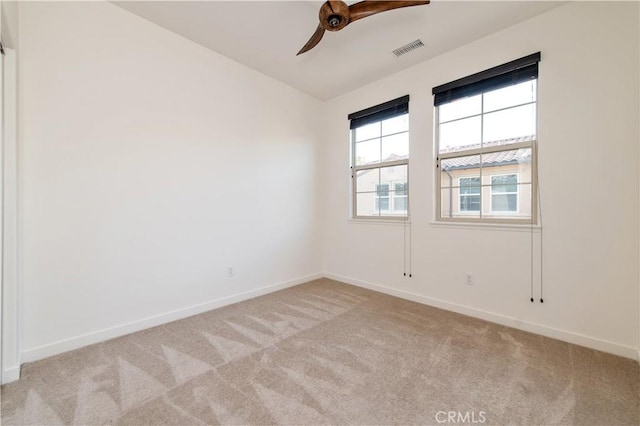 spare room with ceiling fan and light colored carpet