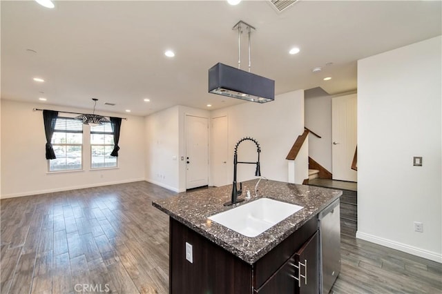 kitchen featuring pendant lighting, sink, a kitchen island with sink, hardwood / wood-style flooring, and stainless steel dishwasher