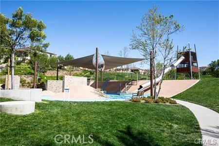 view of home's community featuring a playground and a yard