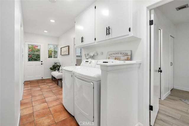 laundry room with separate washer and dryer and cabinets