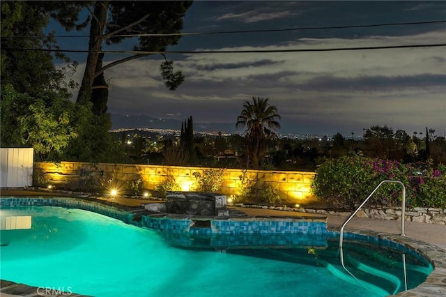 pool at dusk with a jacuzzi