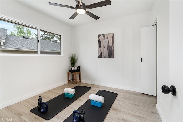 workout area with ceiling fan and light hardwood / wood-style floors