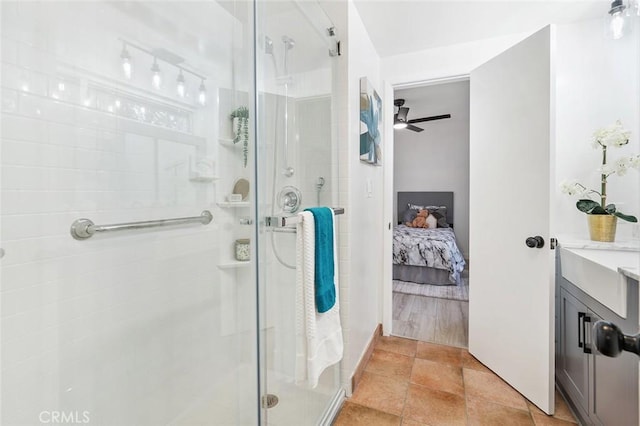 bathroom with ceiling fan, a shower with shower door, and vanity