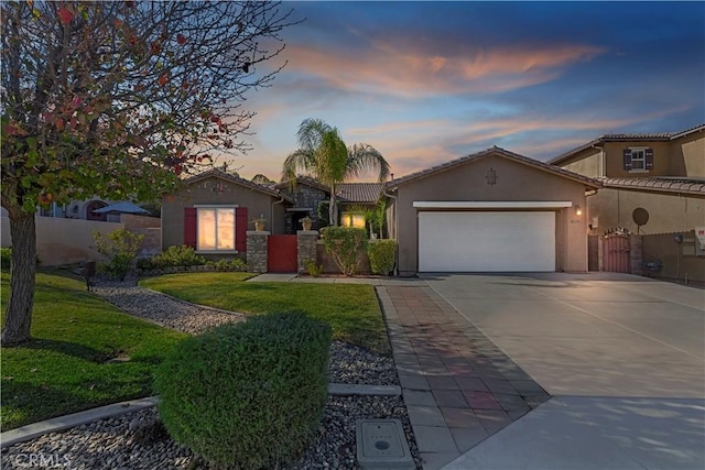 mediterranean / spanish-style home with a yard and a garage