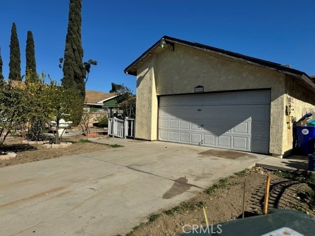 view of property exterior with a garage and an outdoor structure