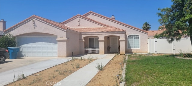 mediterranean / spanish-style home with a front yard and a garage