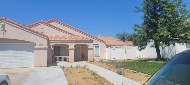 mediterranean / spanish-style house featuring a front yard and a garage