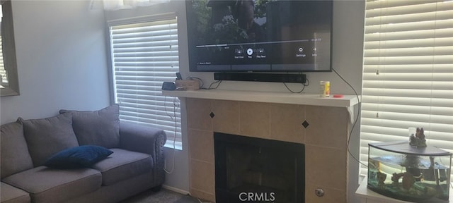 living room featuring a tiled fireplace