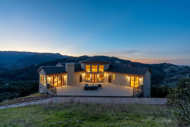 back house at dusk featuring an outdoor hangout area and a deck with mountain view