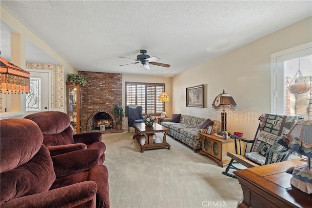 living room with a fireplace, a textured ceiling, light colored carpet, and ceiling fan