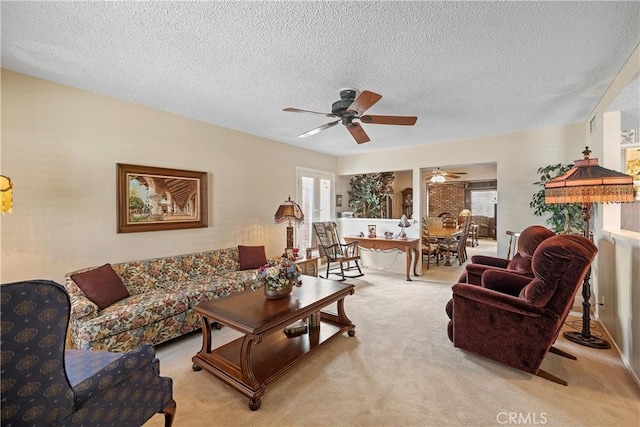 living room featuring a textured ceiling, light colored carpet, and ceiling fan