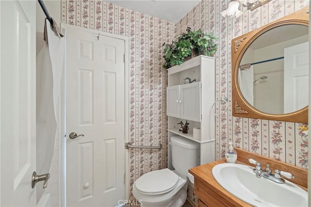 bathroom featuring toilet, a shower, and vanity