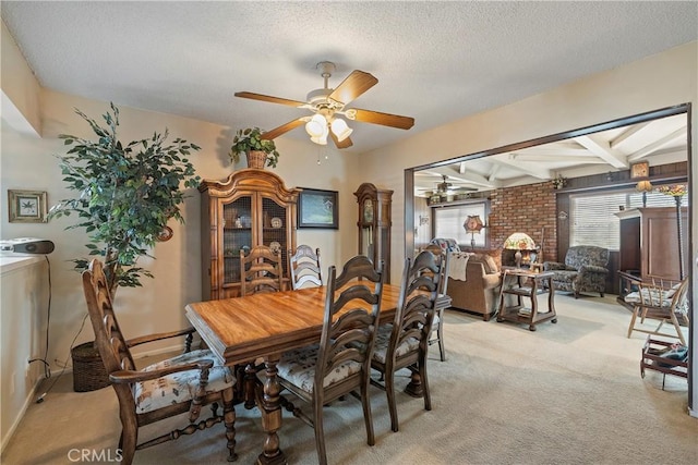 dining area featuring a textured ceiling, ceiling fan, beamed ceiling, and light colored carpet