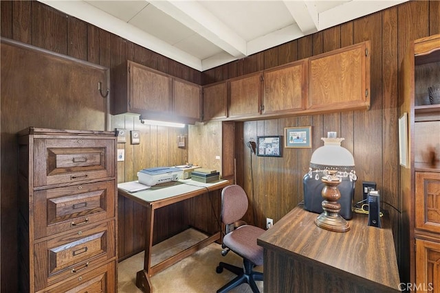 carpeted office with beam ceiling and wood walls