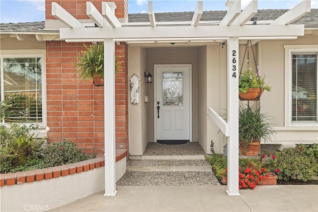 view of exterior entry featuring a pergola