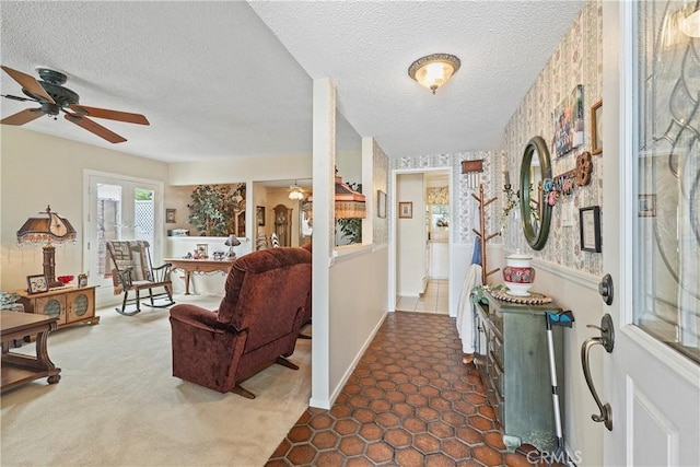 hall featuring a textured ceiling and dark colored carpet