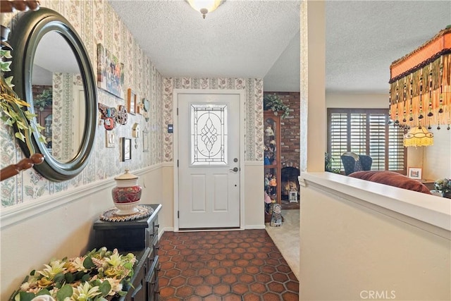 entrance foyer with a textured ceiling and dark tile patterned flooring