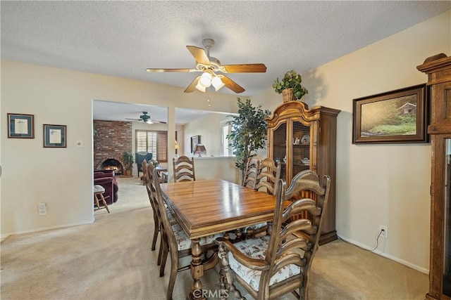 carpeted dining room with a fireplace, a textured ceiling, and ceiling fan