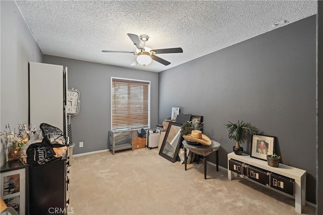 misc room featuring a textured ceiling, light colored carpet, and ceiling fan