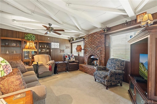 carpeted living room featuring ceiling fan, lofted ceiling with beams, wood walls, and a fireplace