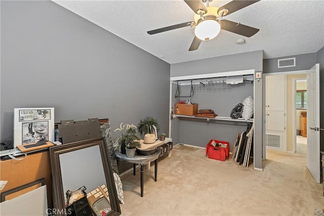 carpeted bedroom featuring a textured ceiling and ceiling fan