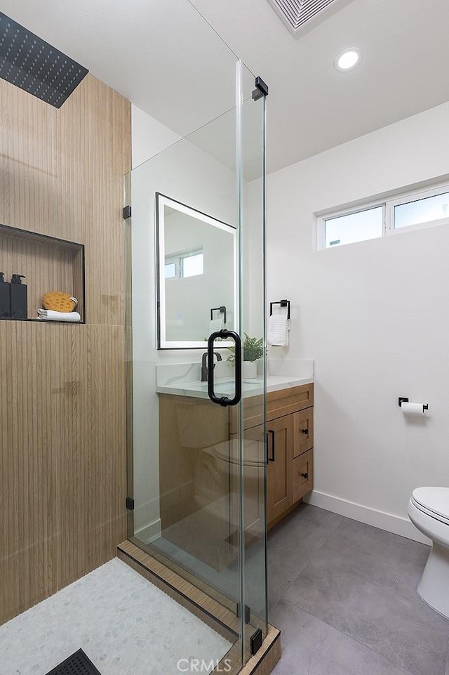 bathroom featuring toilet, an enclosed shower, concrete floors, and vanity