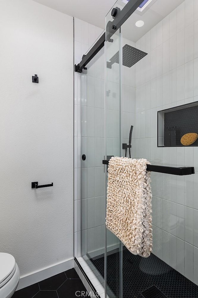 bathroom with tile patterned flooring, an enclosed shower, and toilet