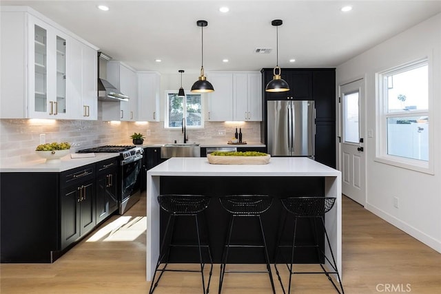 kitchen featuring a center island, appliances with stainless steel finishes, light hardwood / wood-style flooring, and sink