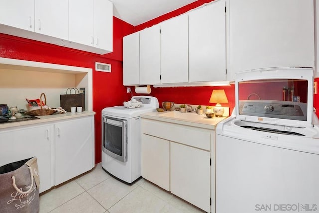 washroom with washing machine and dryer, cabinets, light tile patterned flooring, and sink