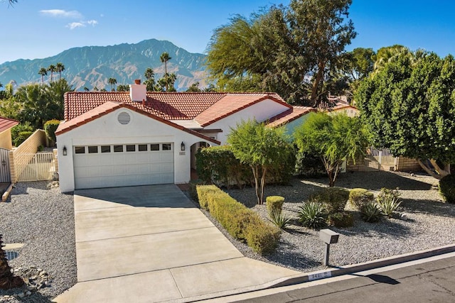 mediterranean / spanish-style house with a garage and a mountain view