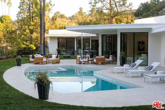 rear view of property with outdoor lounge area and a patio